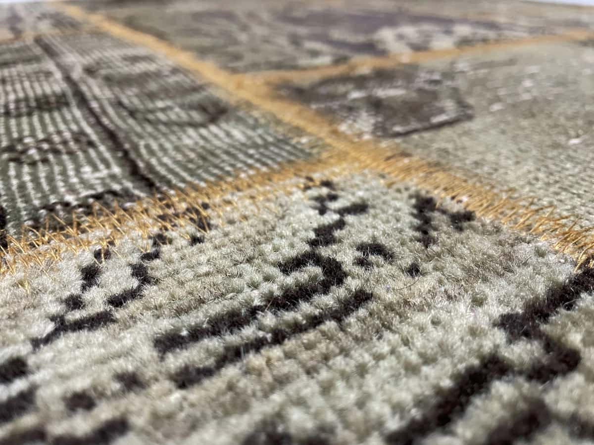 alfombra persa de estilo patchwork en dimensiones 202 centímetros de largo por 140 centímetros de ancho con colores principalmente verde — Primer plano de la textura