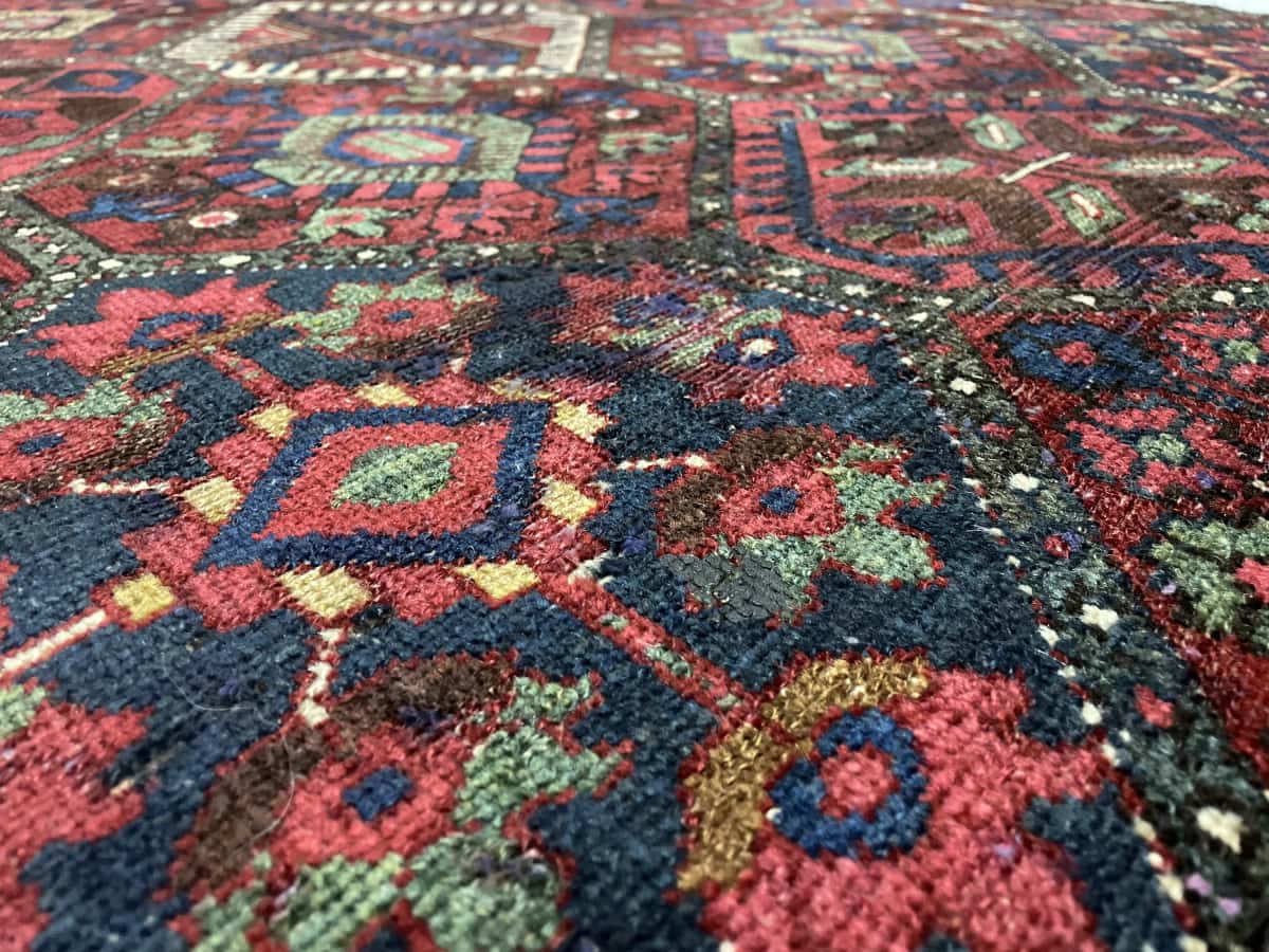 Persian rug of Bakhtiari style in dimensions 220 centimeters length by 105 centimeters width with mainly red and blue colors — Texture close-up