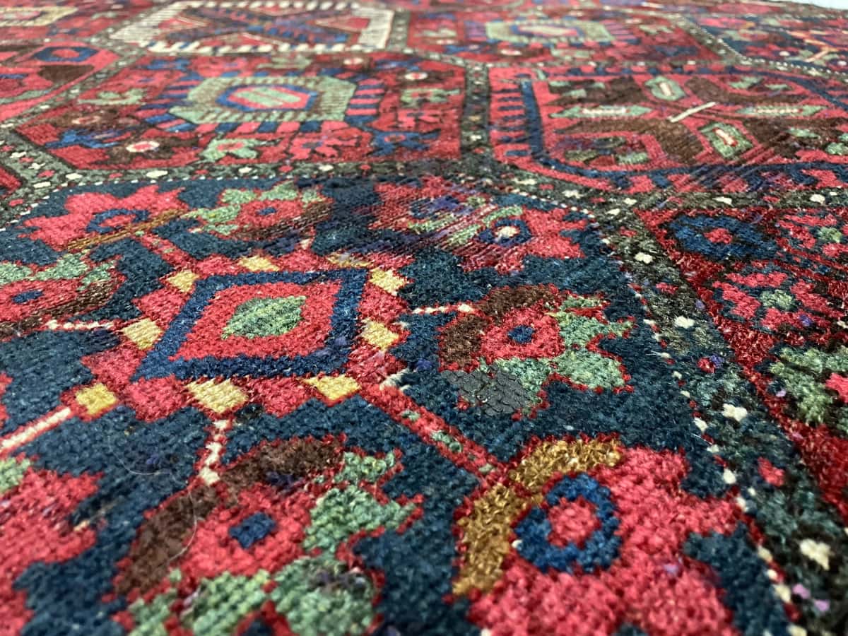 alfombra persa de estilo bakhtiari en dimensiones 220 centímetros de largo por 105 centímetros de ancho con colores principalmente rojo y azul — Primer plano de la textura