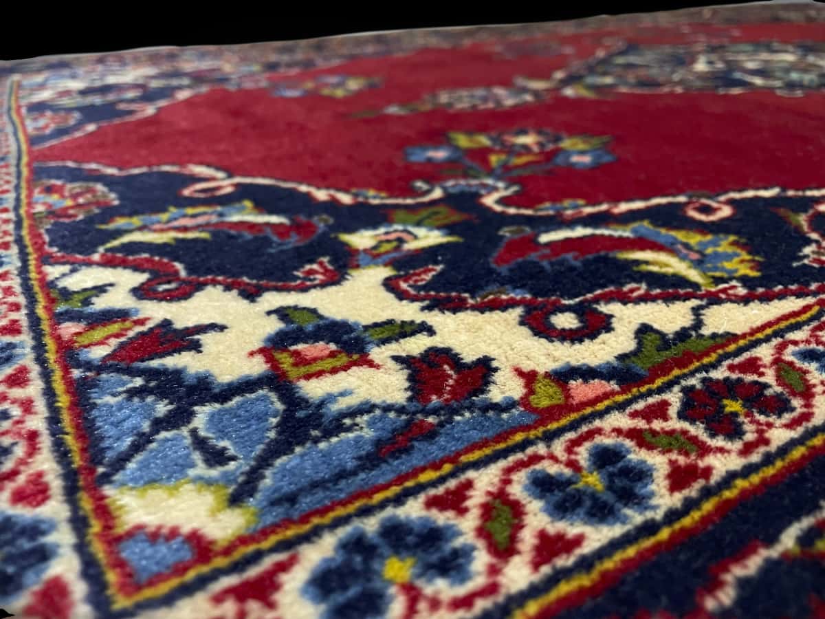 Persian rug of Kashan style in dimensions 137 centimeters length by 83 centimeters width with mainly red colors — Texture close-up
