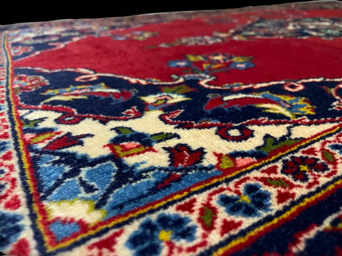 Persian rug of Kashan style in dimensions 137 centimeters length by 83 centimeters width with mainly red colors — Texture close-up
