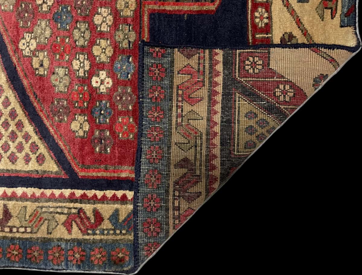 Persian rug of Meshginshahr style in dimensions 134 centimeters length by 116 centimeters width with mainly blue and red colors — Folded