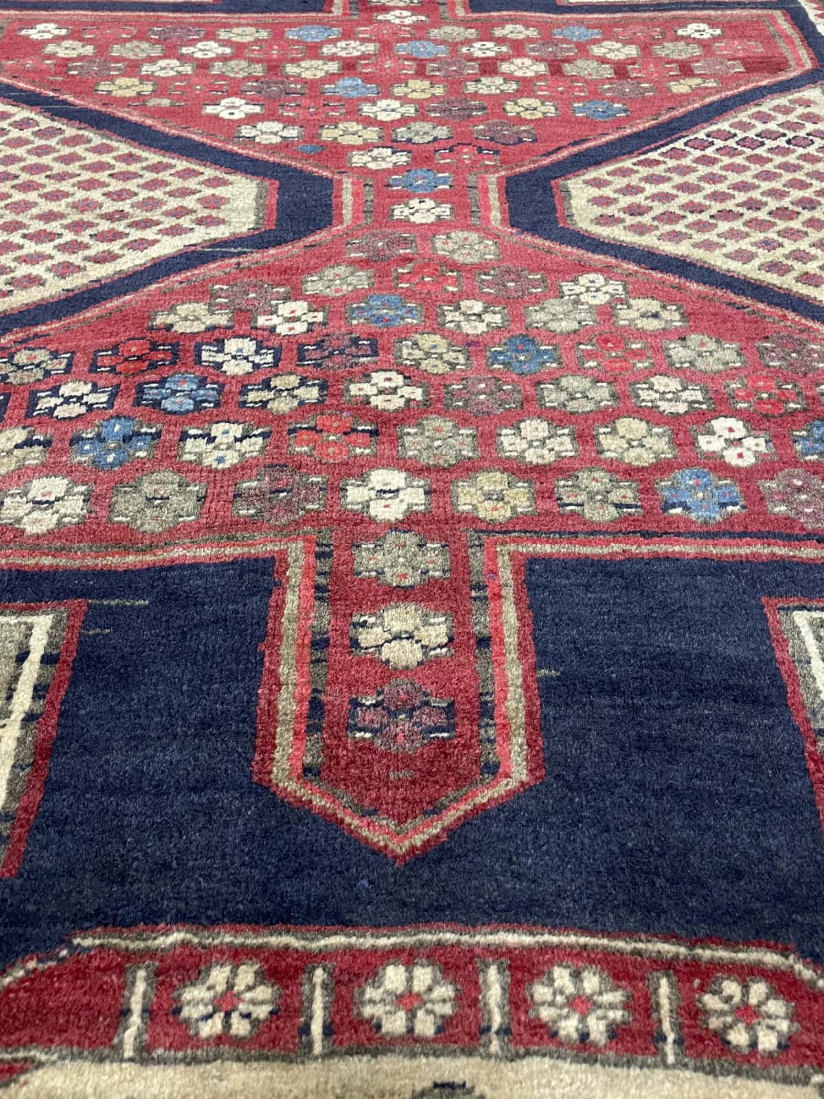 Persian rug of Meshginshahr style in dimensions 134 centimeters length by 116 centimeters width with mainly blue and red colors — Texture close-up