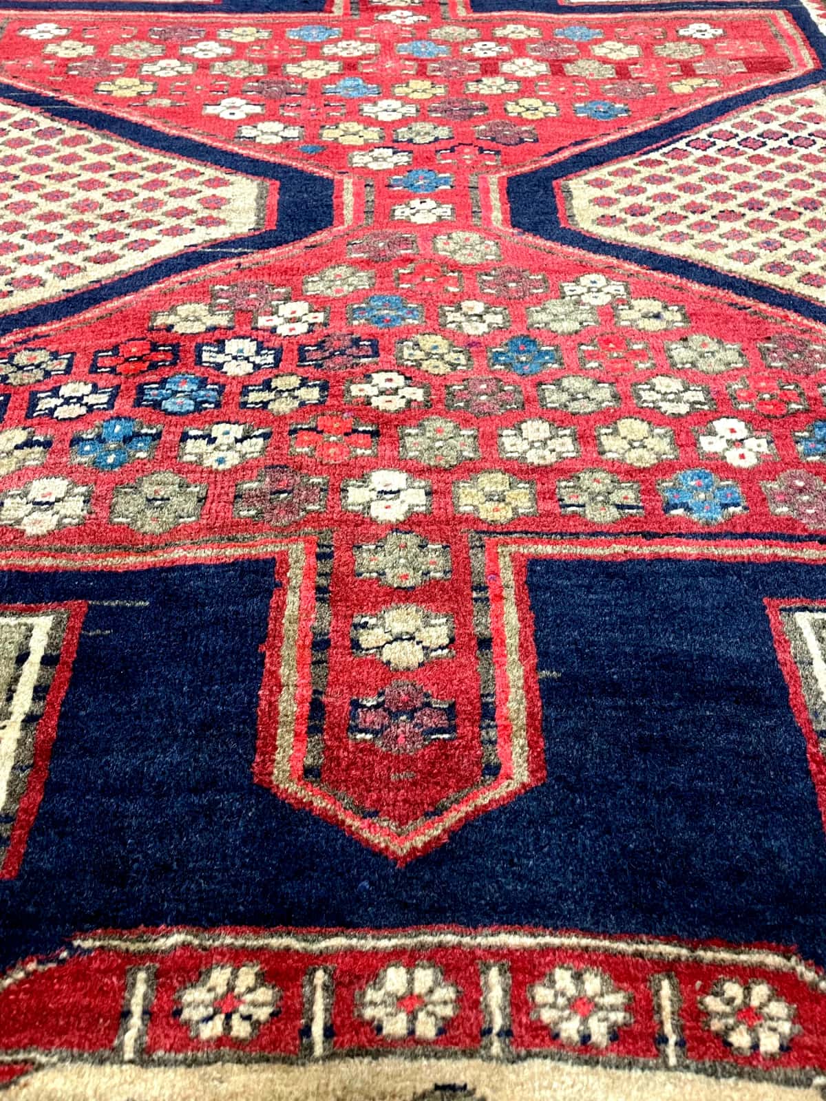 persischer Teppich im Meshginshahr Stil in den Maßen 134 Zentimeter Länge mal 116 Zentimeter Breite mit überwiegend rot Farben — Nahaufnahme der Textur