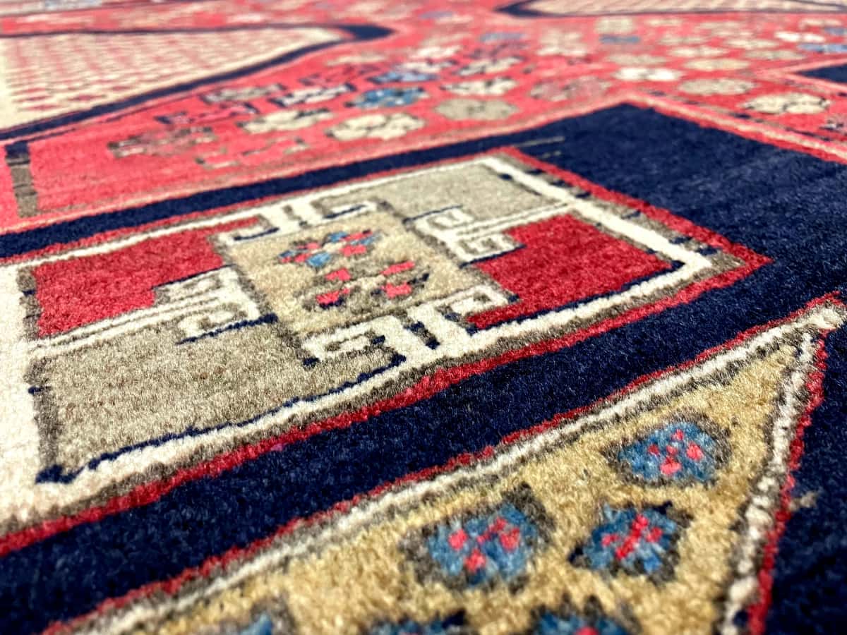 persischer Teppich im Meshginshahr Stil in den Maßen 134 Zentimeter Länge mal 116 Zentimeter Breite mit überwiegend rot Farben — Nahaufnahme der Textur