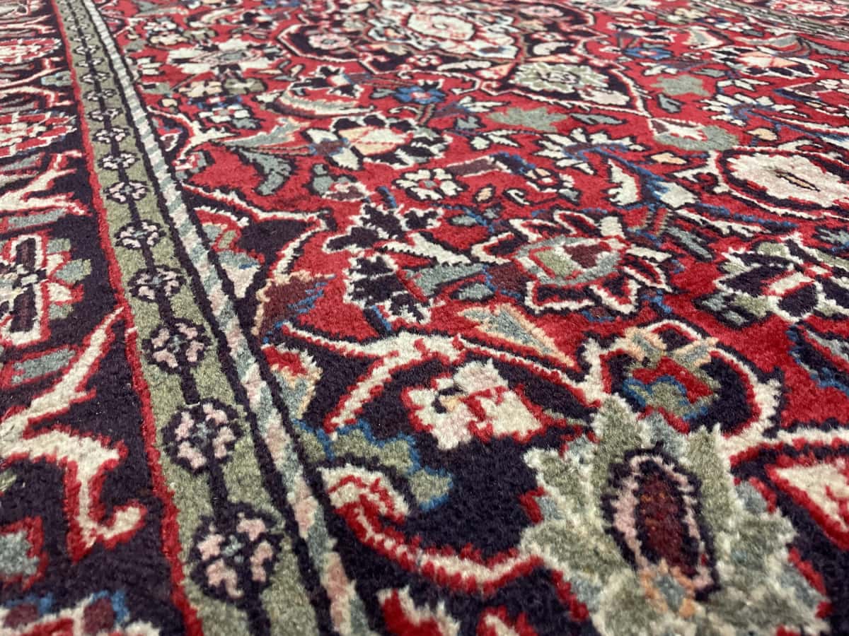 Persian rug of Aran va Bidgol style in dimensions 200 centimeters length by 125 centimeters width with mainly red and green colors — Texture close-up