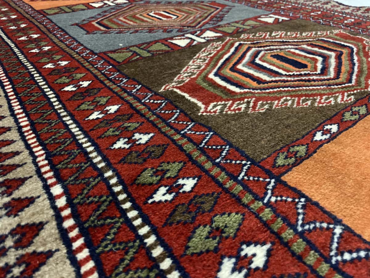 Persian rug of Quchan style in dimensions 175 centimeters length by 105 centimeters width with mainly red and orange colors — Texture close-up