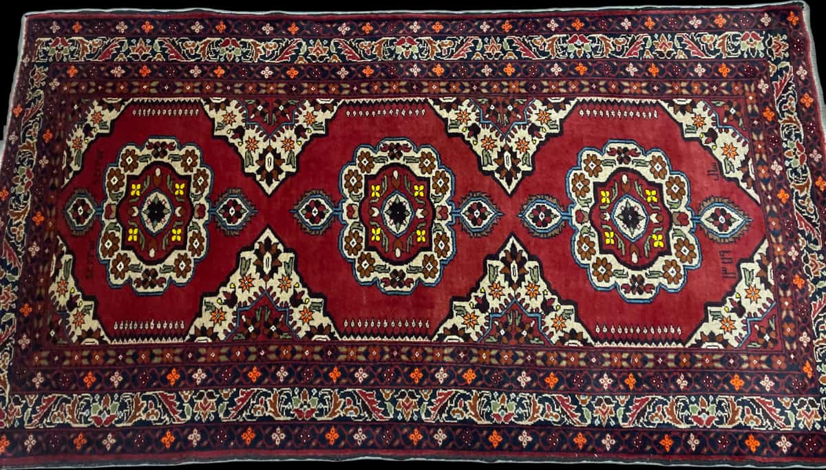 persischer Teppich im Baluch Stil in den Maßen 198 Zentimeter Länge mal 111 Zentimeter Breite mit überwiegend rot und orange Farben — Perspektive