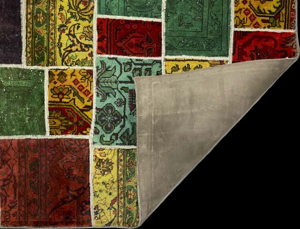alfombra persa de estilo patchwork en dimensiones 200 centímetros de largo por 136 centímetros de ancho con colores principalmente rojo y verde — Plegada