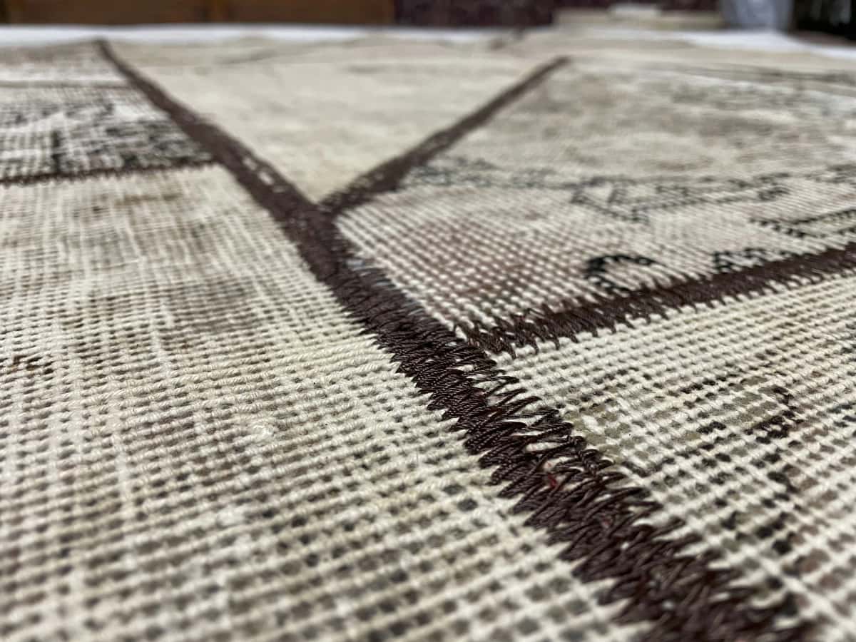 alfombra persa de estilo patchwork en dimensiones 238 centímetros de largo por 160 centímetros de ancho con colores principalmente beige y marrón — Primer plano de la textura