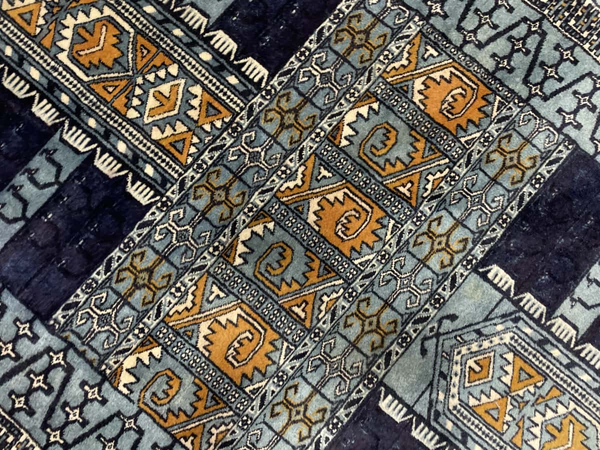 Persian rug of Turkoman style in dimensions 166 centimeters length by 95 centimeters width with mainly blue colors — Texture close-up