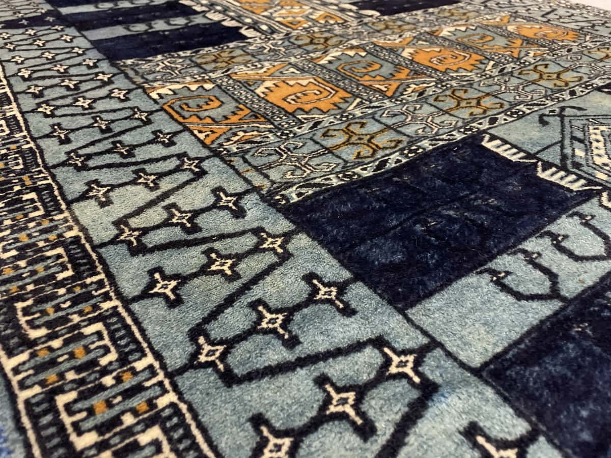Persian rug of Turkoman style in dimensions 166 centimeters length by 95 centimeters width with mainly blue colors — Texture close-up