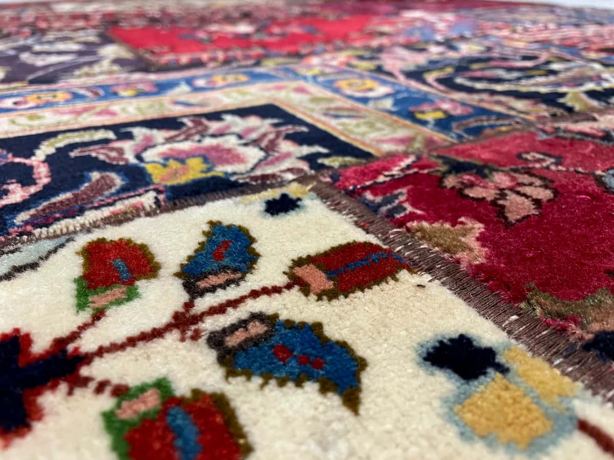 Persian rug of Rey style in dimensions 235 centimeters length by 151 centimeters width with mainly red colors — Texture close-up