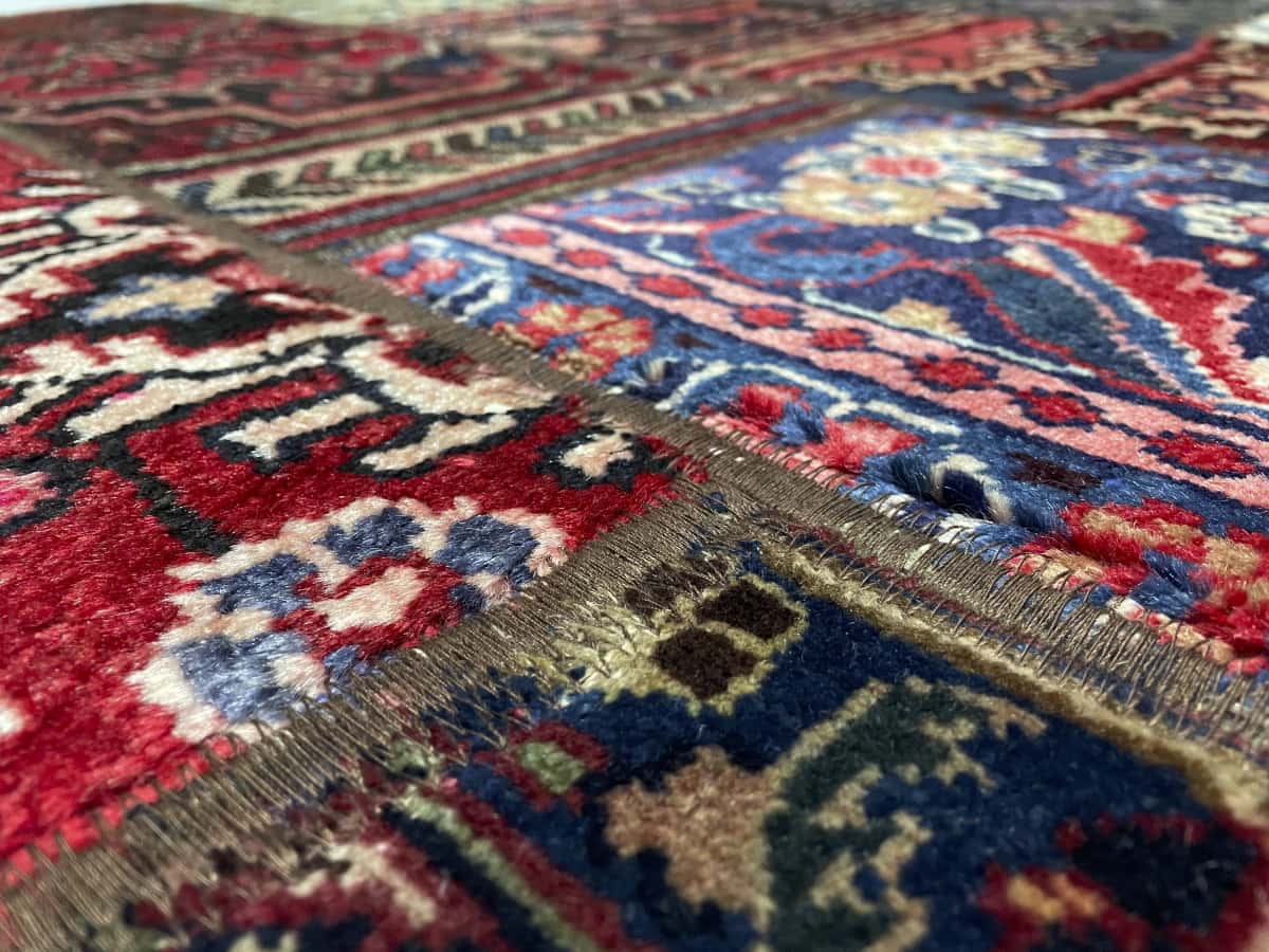 alfombra persa de estilo patchwork en dimensiones 202 centímetros de largo por 152 centímetros de ancho con colores principalmente rojo y azul — Primer plano de la textura