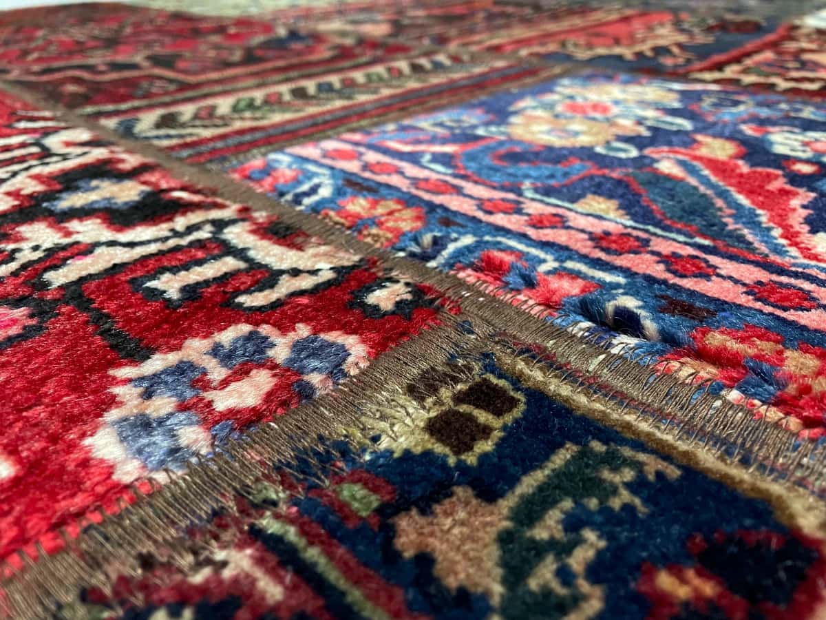 Persian rug of Rey style in dimensions 202 centimeters length by 152 centimeters width with mainly red and blue colors — Texture close-up