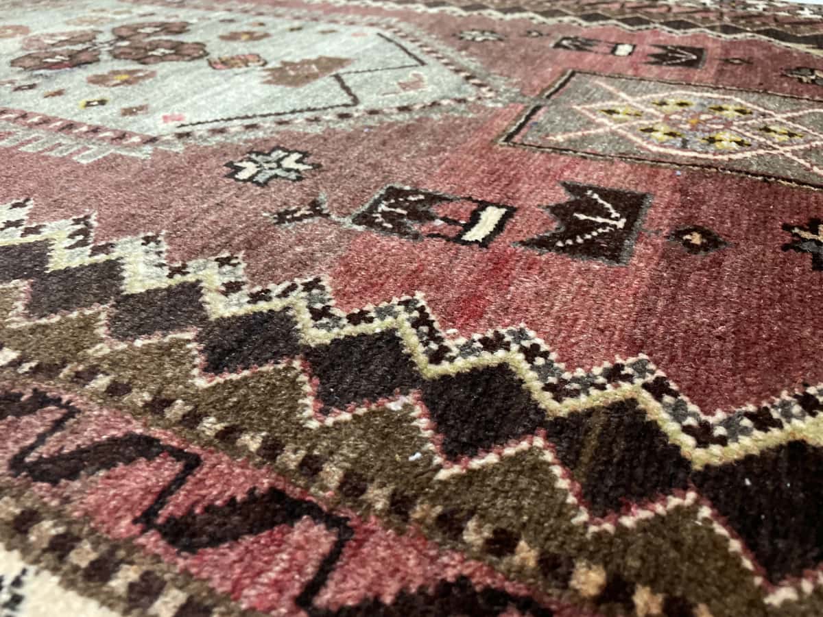 Persian rug of Zanjan style in dimensions 215 centimeters length by 100 centimeters width with mainly green and brown colors — Texture close-up