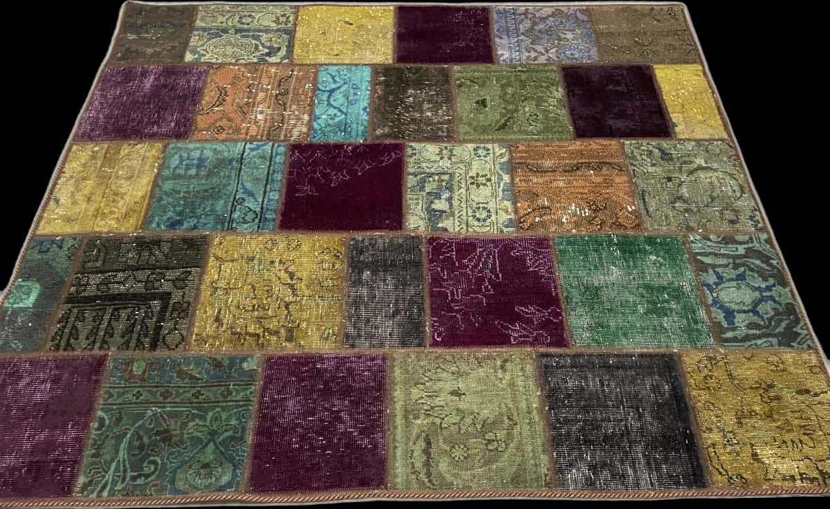 alfombra persa de estilo patchwork en dimensiones 172 centímetros de largo por 150 centímetros de ancho con colores principalmente verde y morado — Plegada