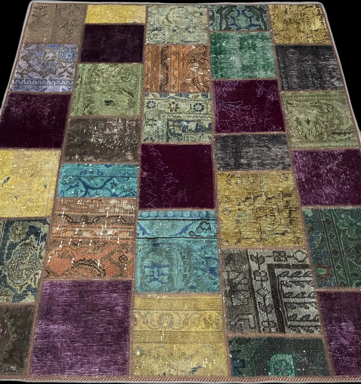 alfombra persa de estilo patchwork en dimensiones 172 centímetros de largo por 150 centímetros de ancho con colores principalmente verde y morado — Perspectiva