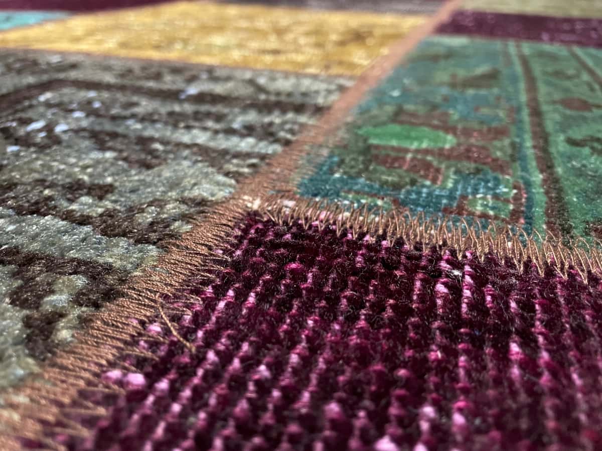 persischer Teppich im Rey Stil in den Maßen 172 Zentimeter Länge mal 150 Zentimeter Breite mit überwiegend grün und lila Farben — Nahaufnahme der Textur