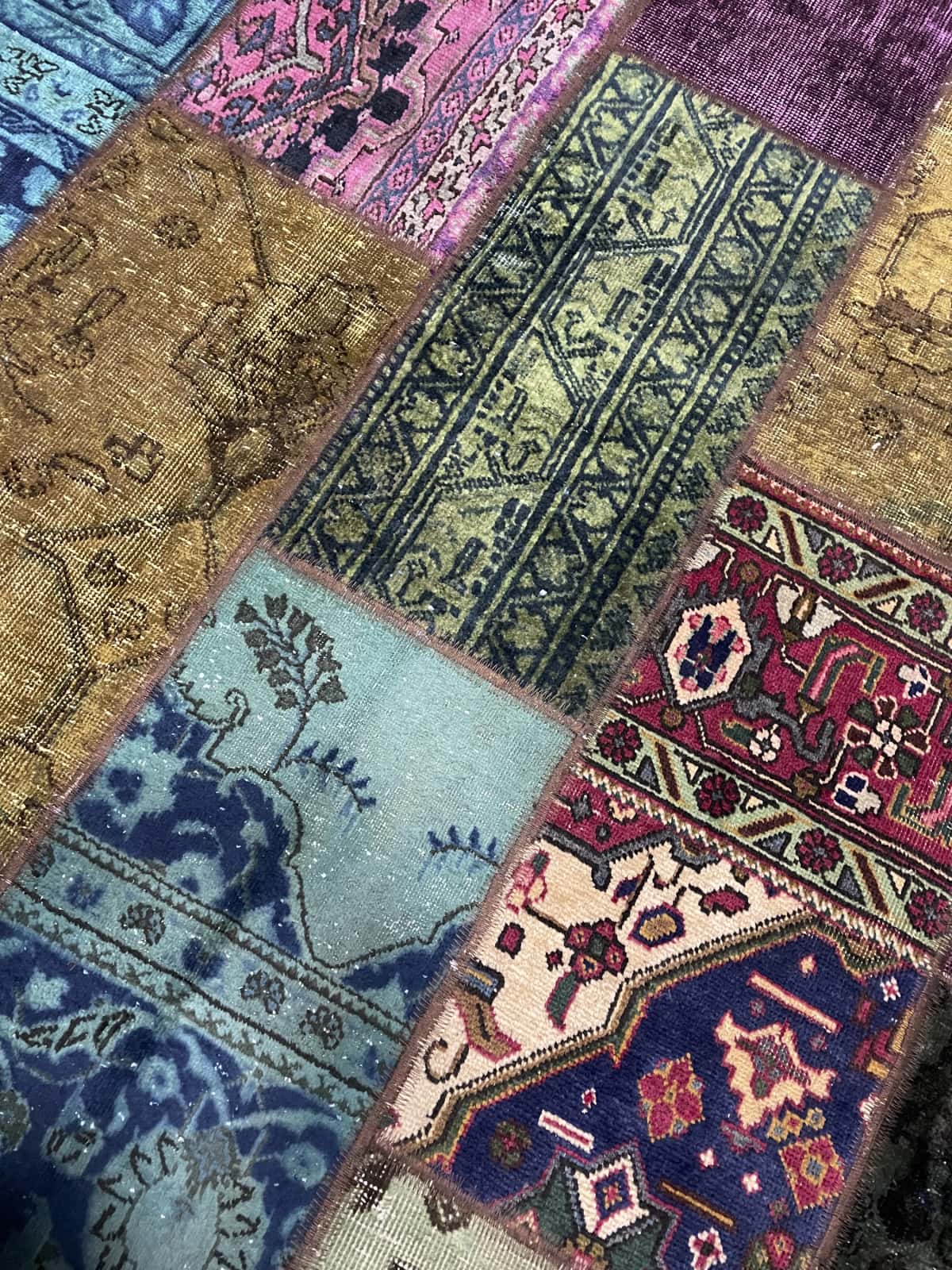 alfombra persa de estilo patchwork en dimensiones 207 centímetros de largo por 152 centímetros de ancho con colores principalmente verde y morado — Primer plano de la textura