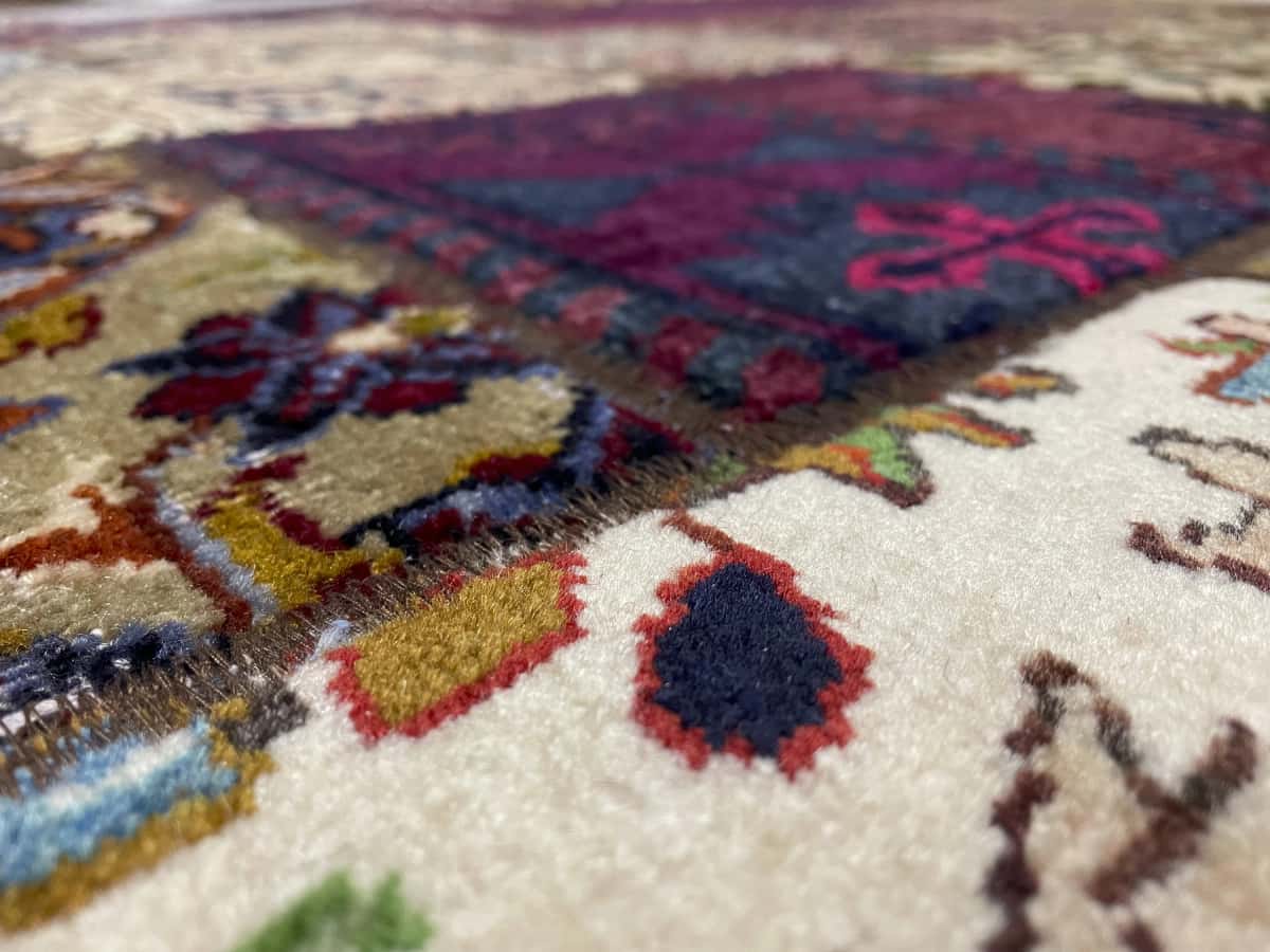 alfombra persa de estilo patchwork en dimensiones 207 centímetros de largo por 151 centímetros de ancho con colores principalmente rojo y amarillo — Primer plano de la textura