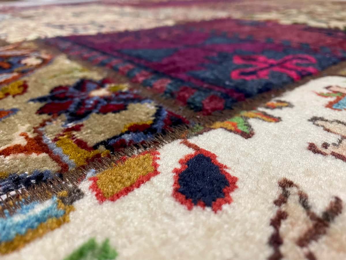 persischer Teppich im Rey Stil in den Maßen 207 Zentimeter Länge mal 151 Zentimeter Breite mit überwiegend rot und gelb Farben — Nahaufnahme der Textur