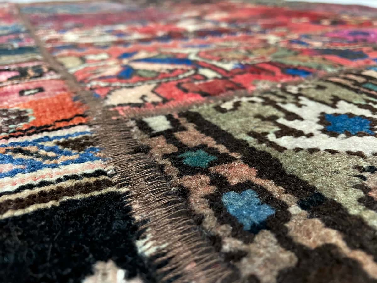 Persian rug of Rey style in dimensions 204 centimeters length by 151 centimeters width with mainly red colors — Texture close-up
