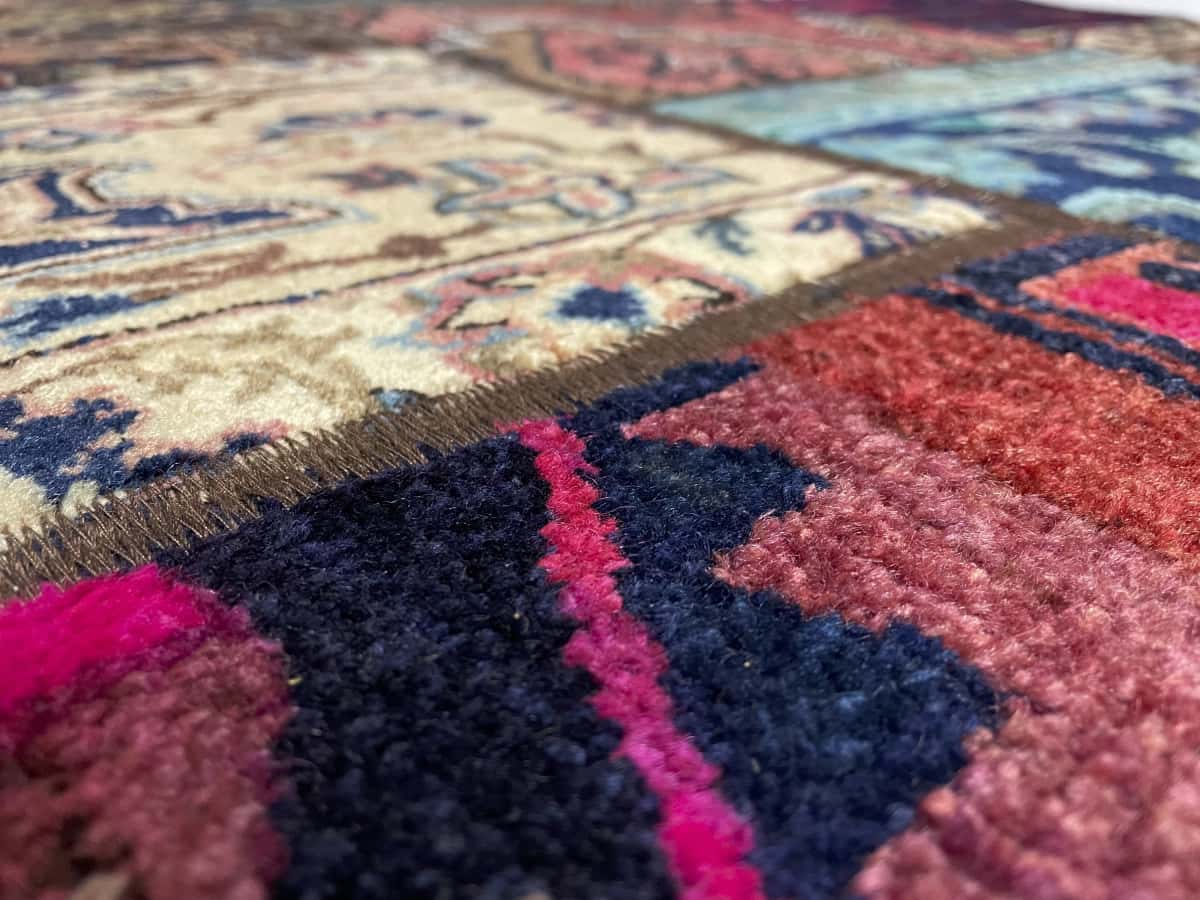 alfombra persa de estilo patchwork en dimensiones 200 centímetros de largo por 147 centímetros de ancho con colores principalmente rojo y colorido — Primer plano de la textura