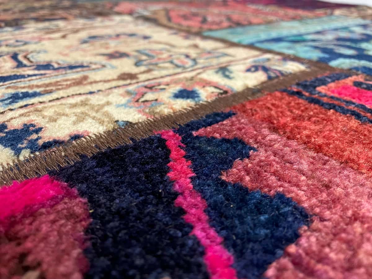 persischer Teppich im Rey Stil in den Maßen 200 Zentimeter Länge mal 147 Zentimeter Breite mit überwiegend rot und bunt Farben — Nahaufnahme der Textur