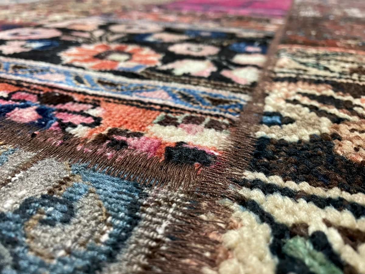 Persian rug of Rey style in dimensions 206 centimeters length by 152 centimeters width with mainly red and purple colors — Texture close-up