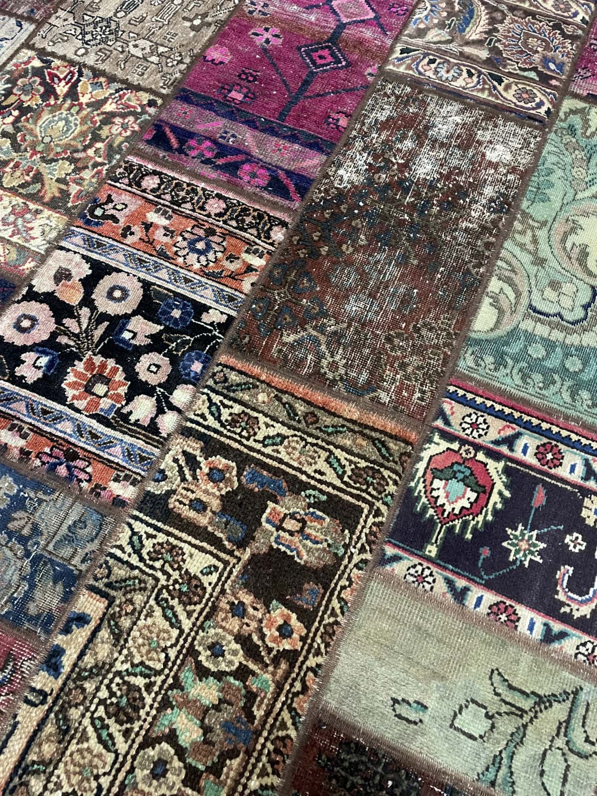 alfombra persa de estilo patchwork en dimensiones 206 centímetros de largo por 152 centímetros de ancho con colores principalmente rojo y morado — Primer plano de la textura
