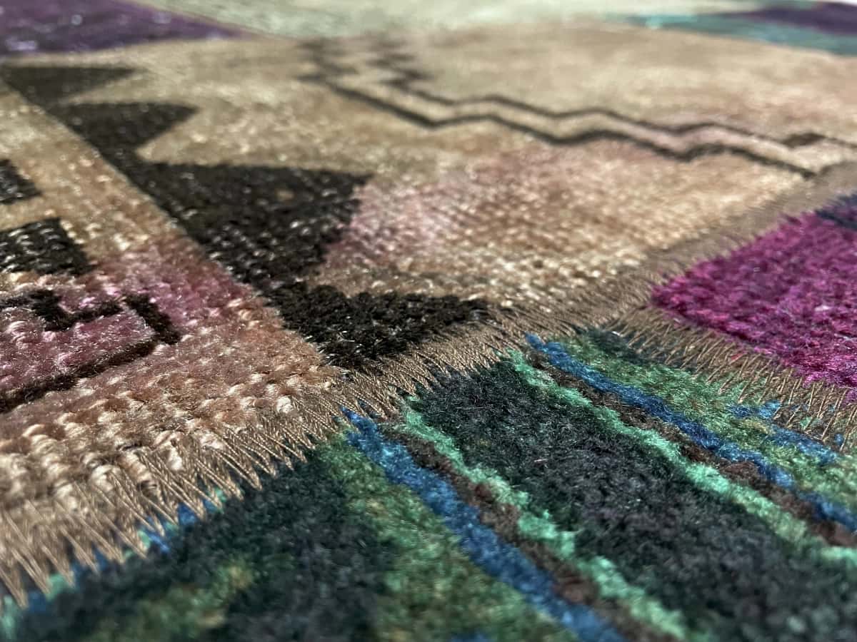 Persian rug of Patchwork style in dimensions 206 centimeters length by 150 centimeters width with mainly green and purple colors — Texture close-up