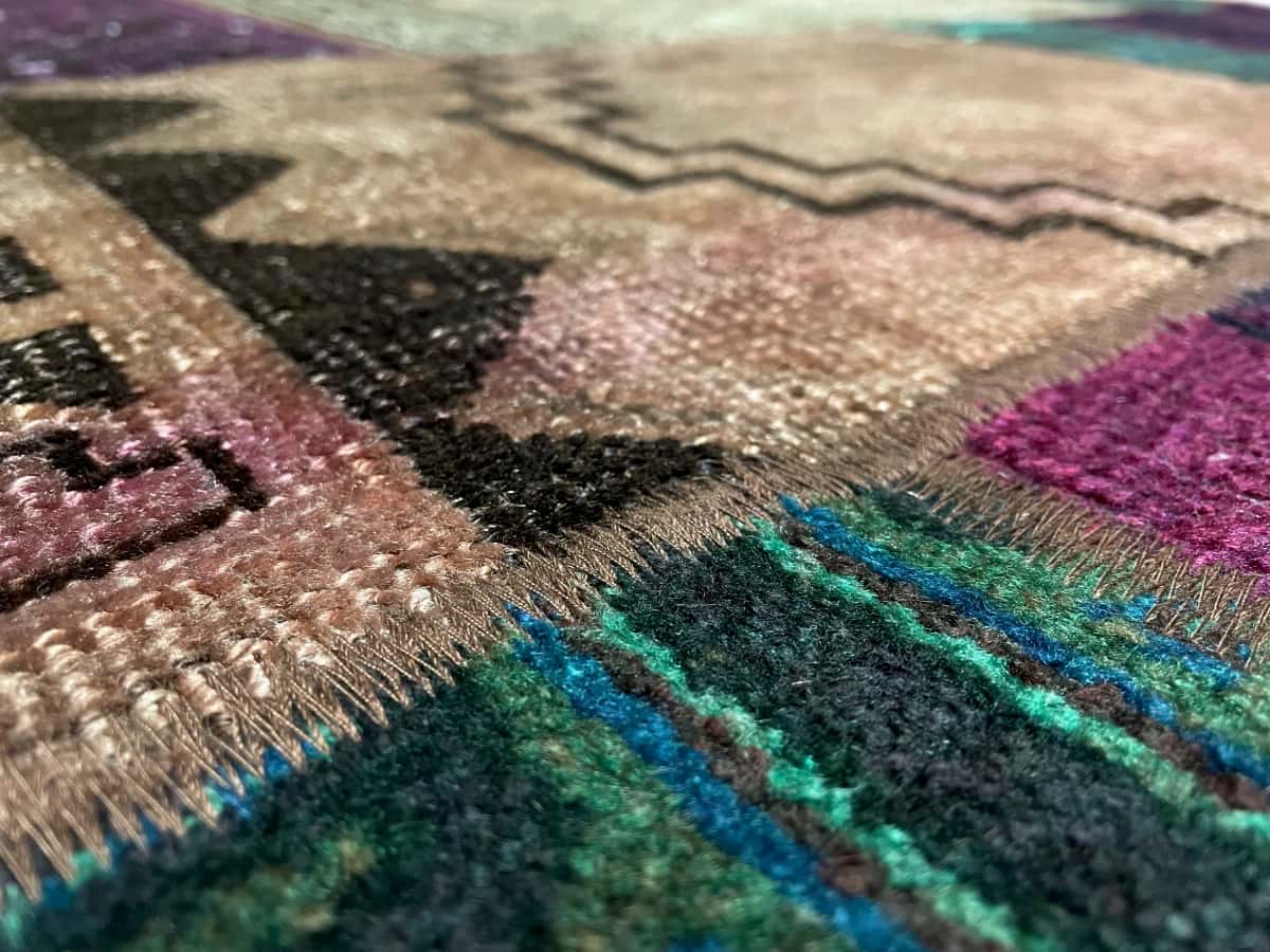 persischer Teppich im Rey Stil in den Maßen 206 Zentimeter Länge mal 150 Zentimeter Breite mit überwiegend grün und lila Farben — Nahaufnahme der Textur