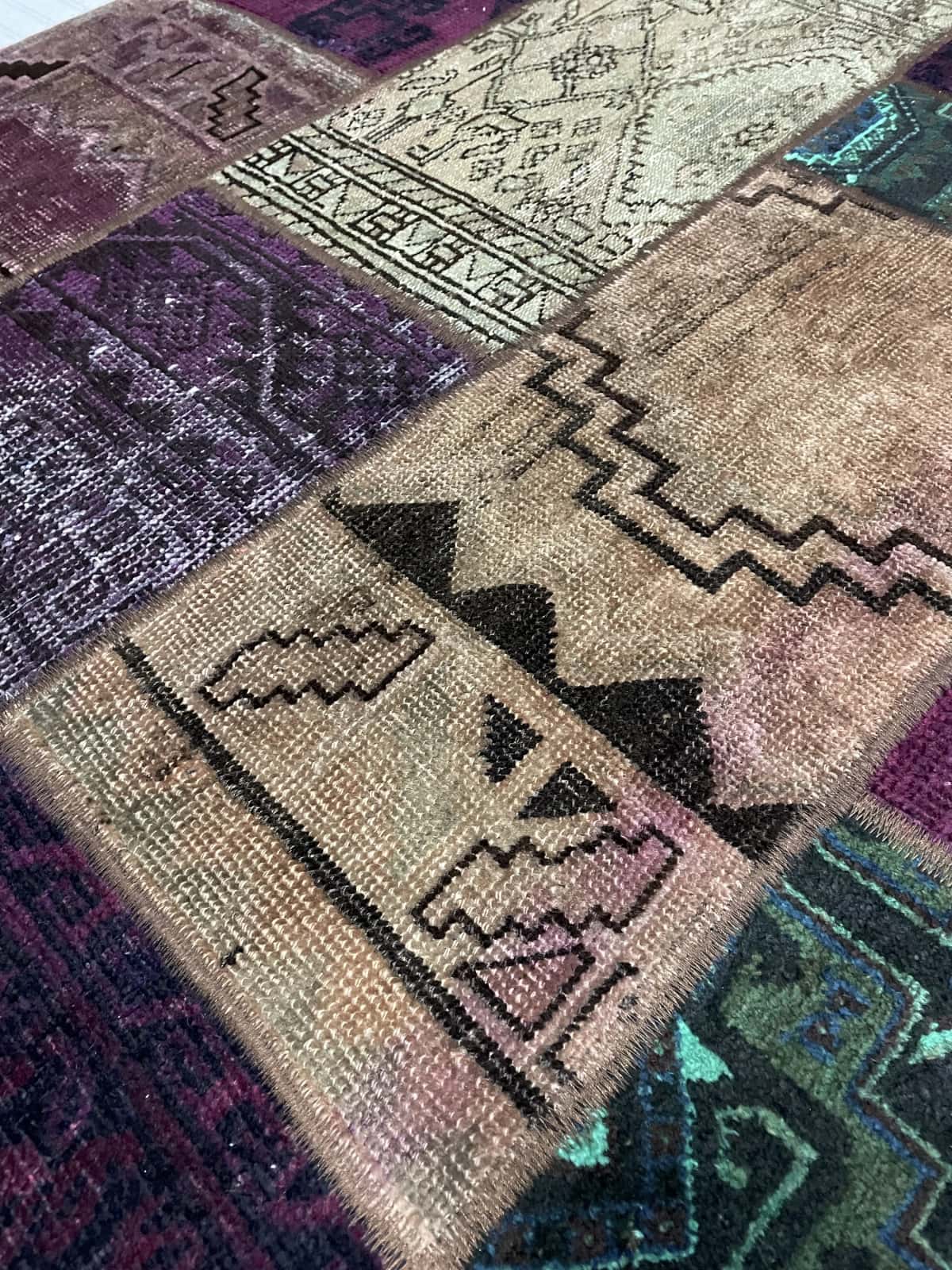 Persian rug of Patchwork style in dimensions 206 centimeters length by 150 centimeters width with mainly green and purple colors — Texture close-up