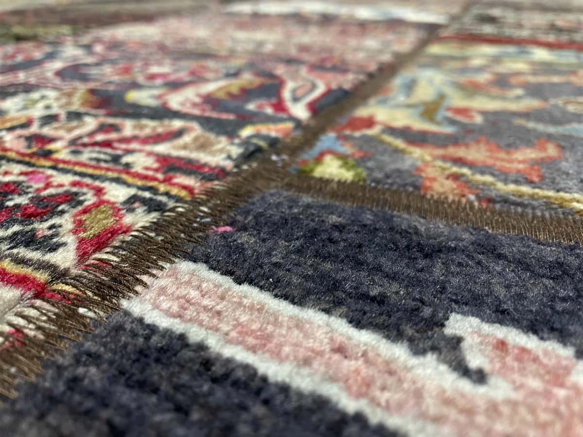 Persian rug of Patchwork style in dimensions 205 centimeters length by 150 centimeters width with mainly beige and red colors — Texture close-up