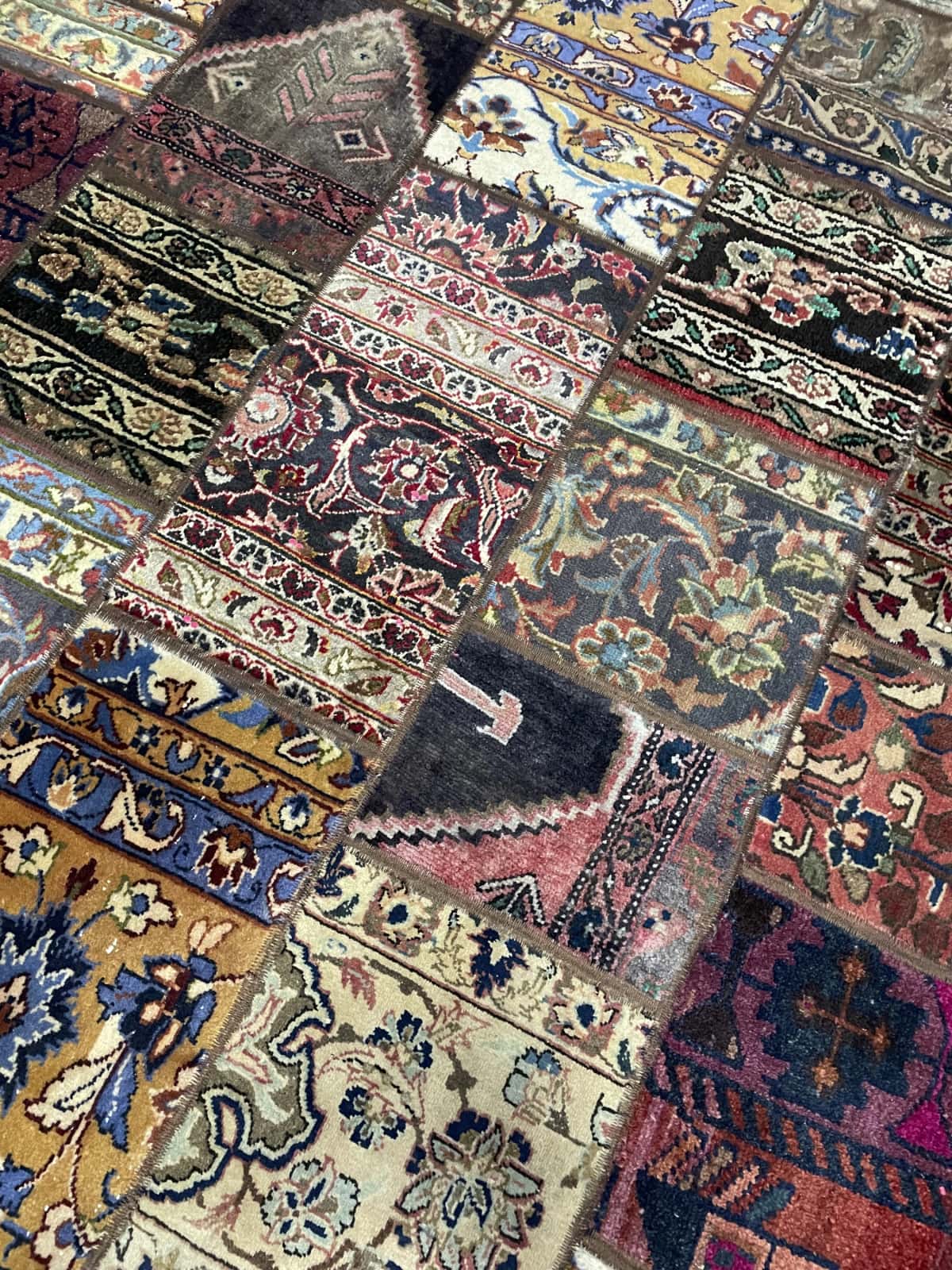 Persian rug of Patchwork style in dimensions 205 centimeters length by 150 centimeters width with mainly beige and red colors — Texture close-up