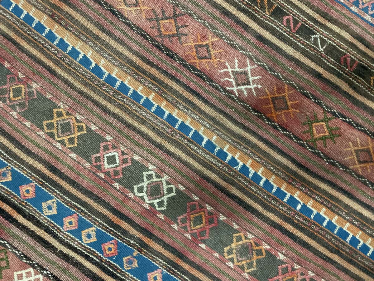 Persian rug of Sumak style in dimensions 136 centimeters length by 115 centimeters width with mainly blue and brown colors — Texture close-up