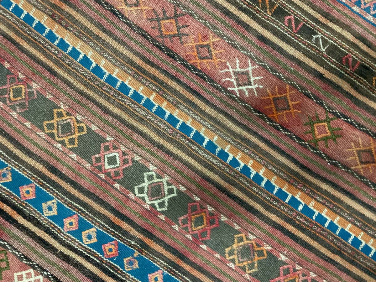 persischer Teppich im Sumak Stil in den Maßen 136 Zentimeter Länge mal 115 Zentimeter Breite mit überwiegend blau und braun Farben — Nahaufnahme der Textur