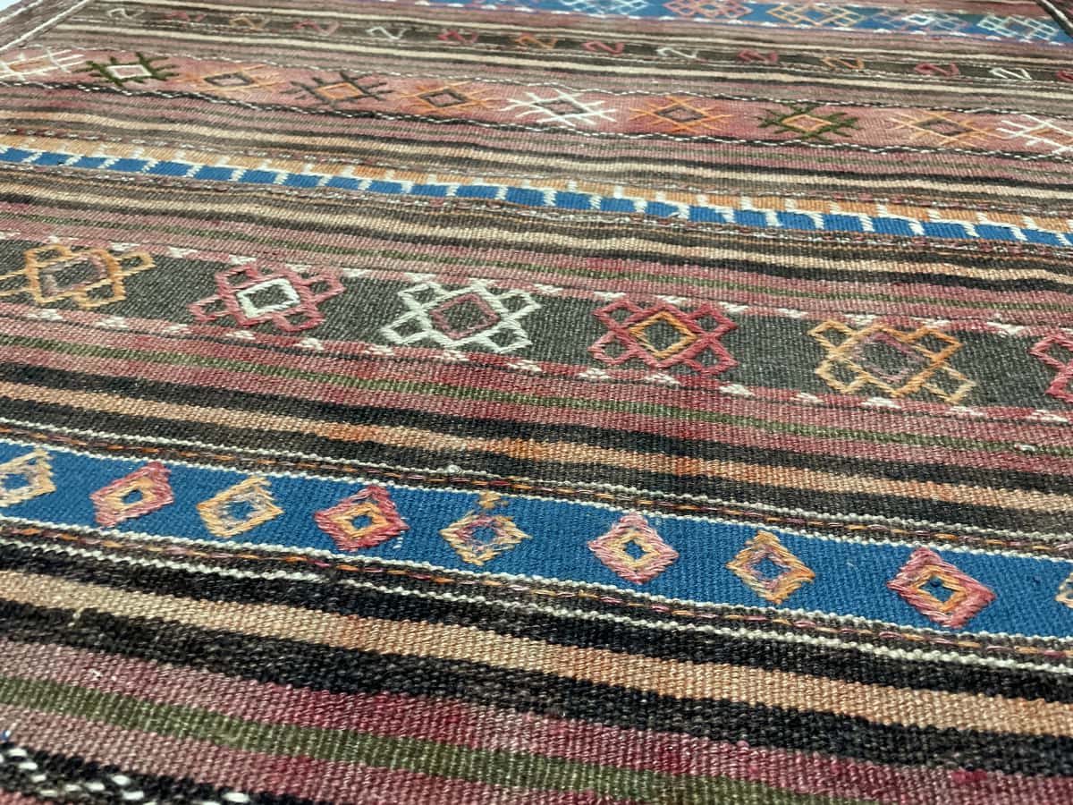 Persian rug of Sumak style in dimensions 136 centimeters length by 115 centimeters width with mainly blue and brown colors — Texture close-up