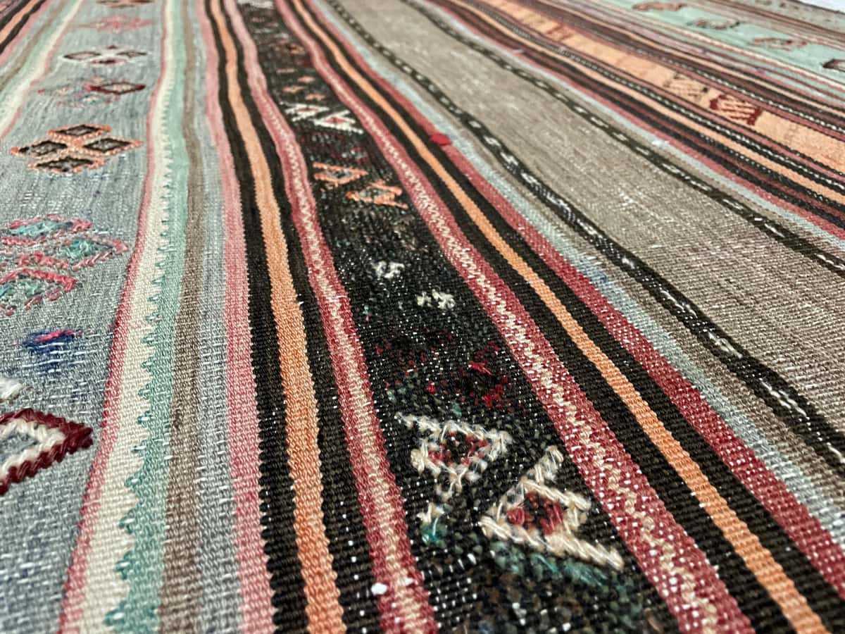 Persian rug of Sumak style in dimensions 148 centimeters length by 108 centimeters width with mainly brown and turquoise colors — Texture close-up