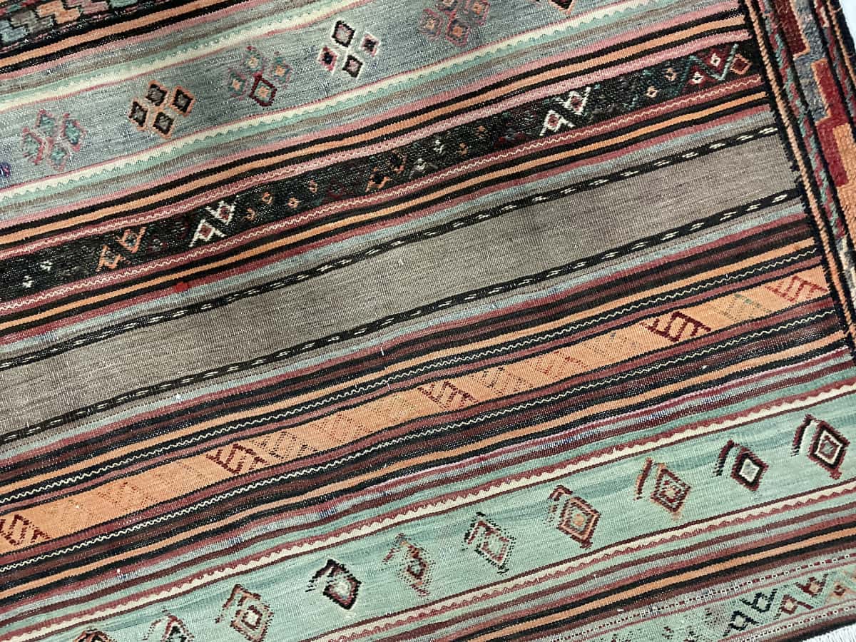 Persian rug of Sumak style in dimensions 148 centimeters length by 108 centimeters width with mainly brown and turquoise colors — Texture close-up