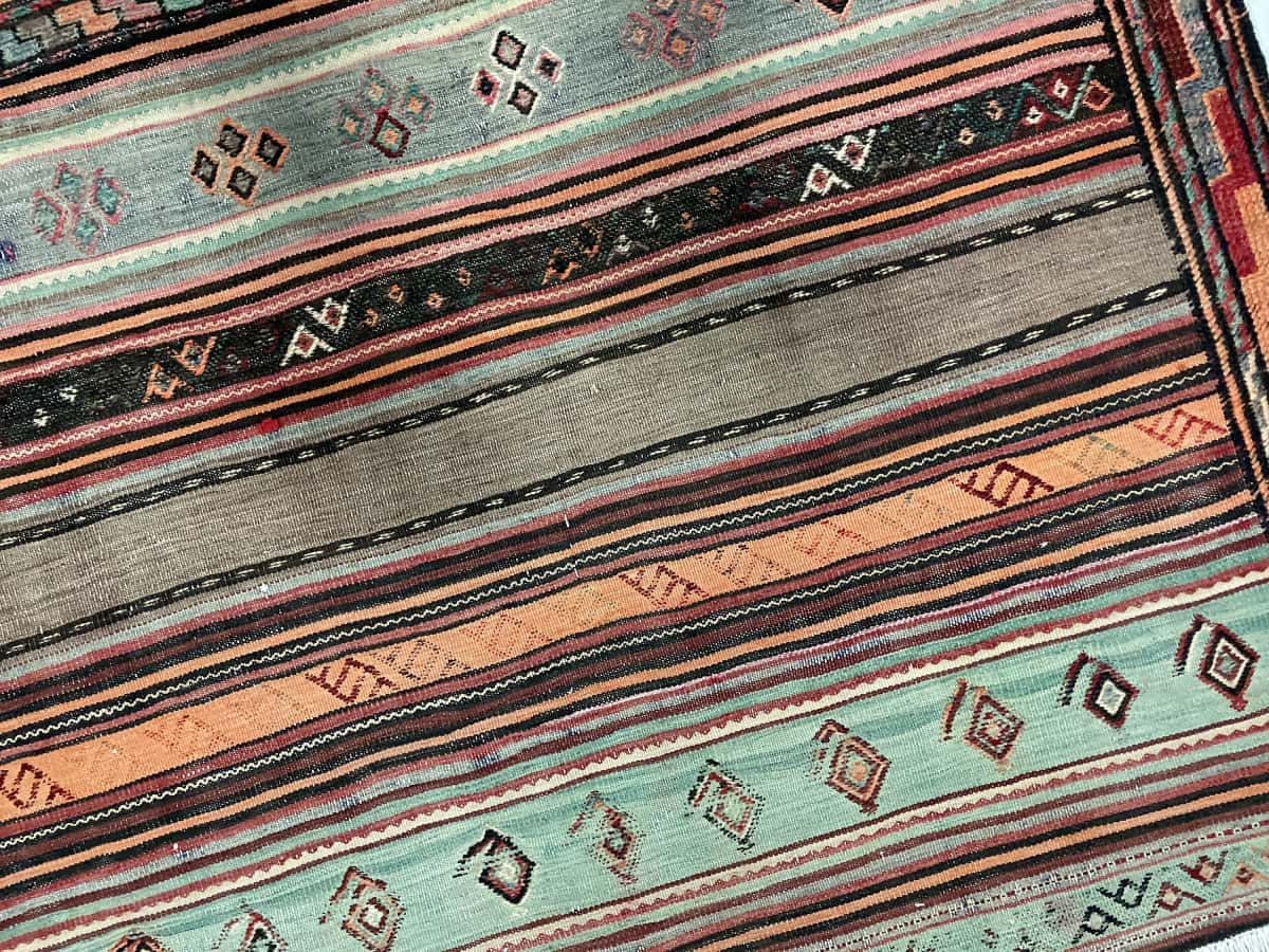 Persian rug of Sumak style in dimensions 148 centimeters length by 108 centimeters width with mainly brown and turquoise colors — Texture close-up