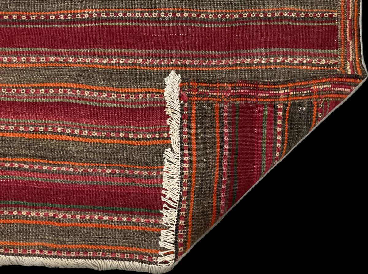 Persian rug of Sumak style in dimensions 177 centimeters length by 131 centimeters width with mainly red and orange colors — Folded