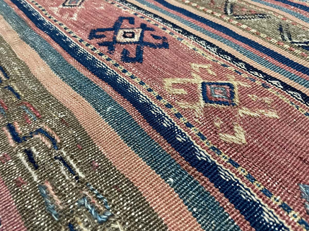 alfombra persa de estilo kilim sumak en dimensiones 245 centímetros de largo por 177 centímetros de ancho con colores principalmente azul y marrón — Primer plano de la textura