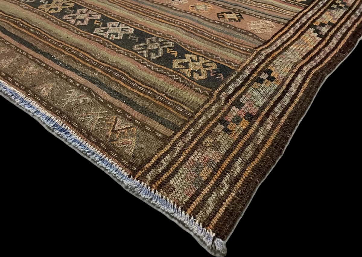 alfombra persa de estilo sumak en dimensiones 228 centímetros de largo por 151 centímetros de ancho con colores principalmente marrón — Esquina y borde
