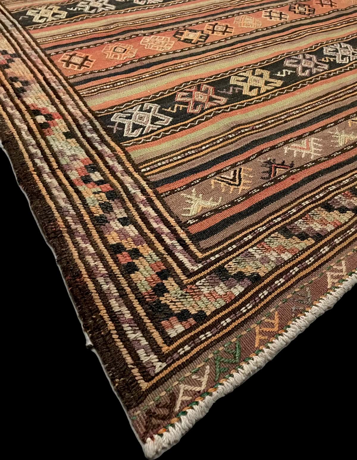 Persian rug of Sumak style in dimensions 228 centimeters length by 151 centimeters width with mainly brown colors — Corner & edge