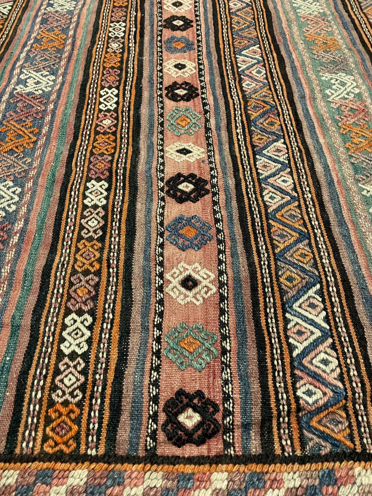Persian rug of Sumak style in dimensions 273 centimeters length by 140 centimeters width with mainly brown colors — Texture close-up