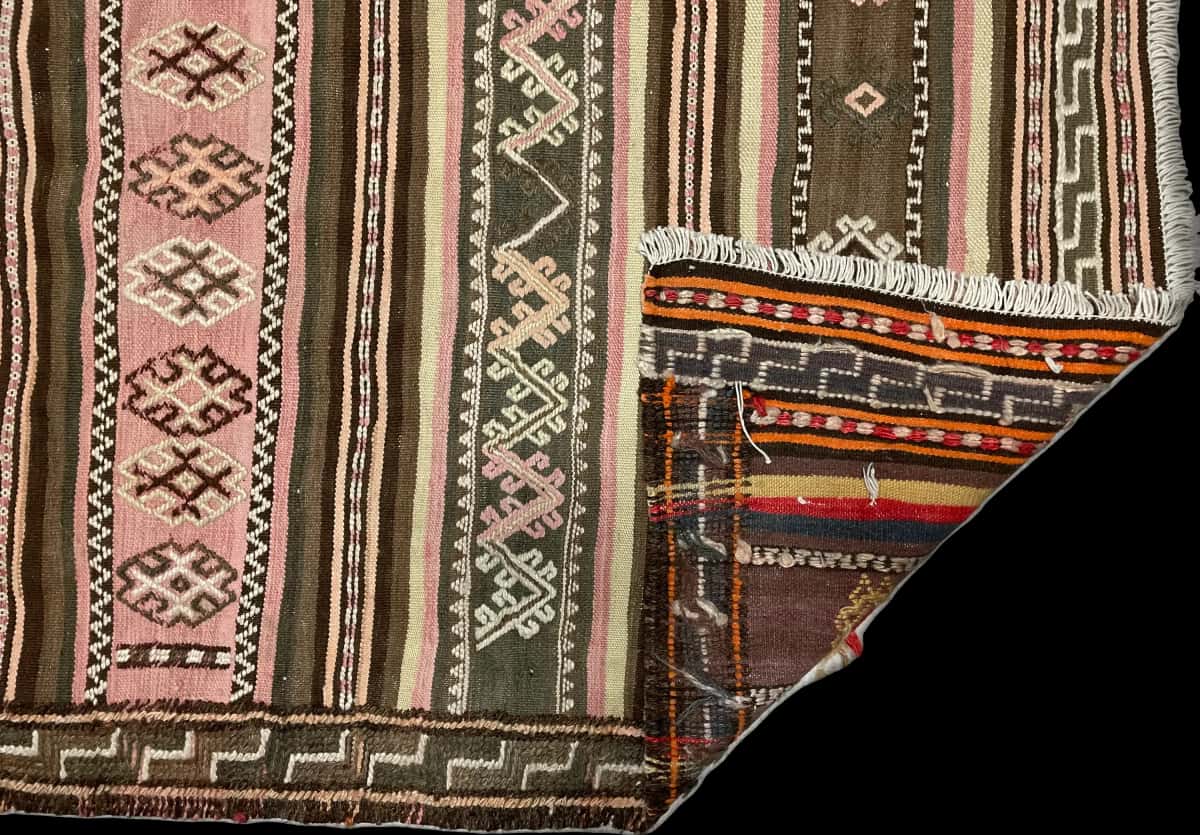 persischer Teppich im Sumak Stil in den Maßen 125 Zentimeter Länge mal 120 Zentimeter Breite mit überwiegend beige und rosa Farben — Gefaltet