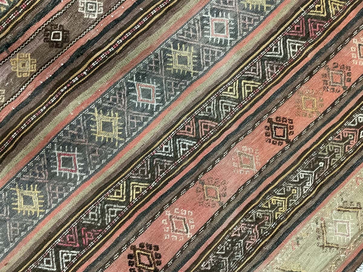 Persian rug of Sumak style in dimensions 152 centimeters length by 112 centimeters width with mainly brown colors — Texture close-up