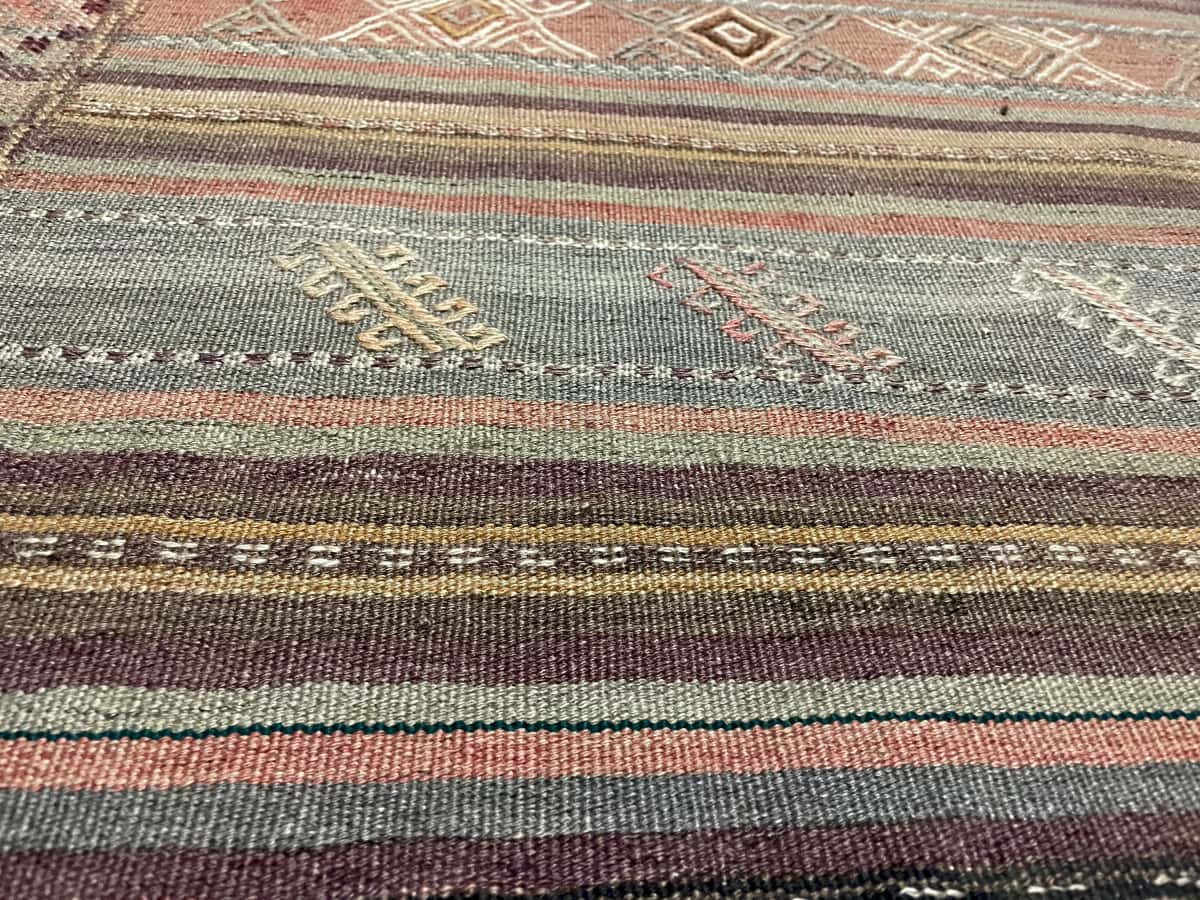 alfombra persa de estilo kilim sumak en dimensiones 250 centímetros de largo por 141 centímetros de ancho con colores principalmente marrón — Primer plano de la textura